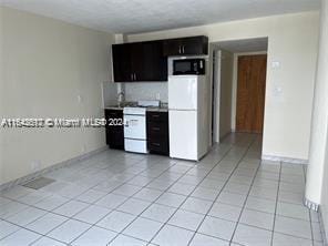 kitchen with white appliances, light tile patterned floors, and tasteful backsplash