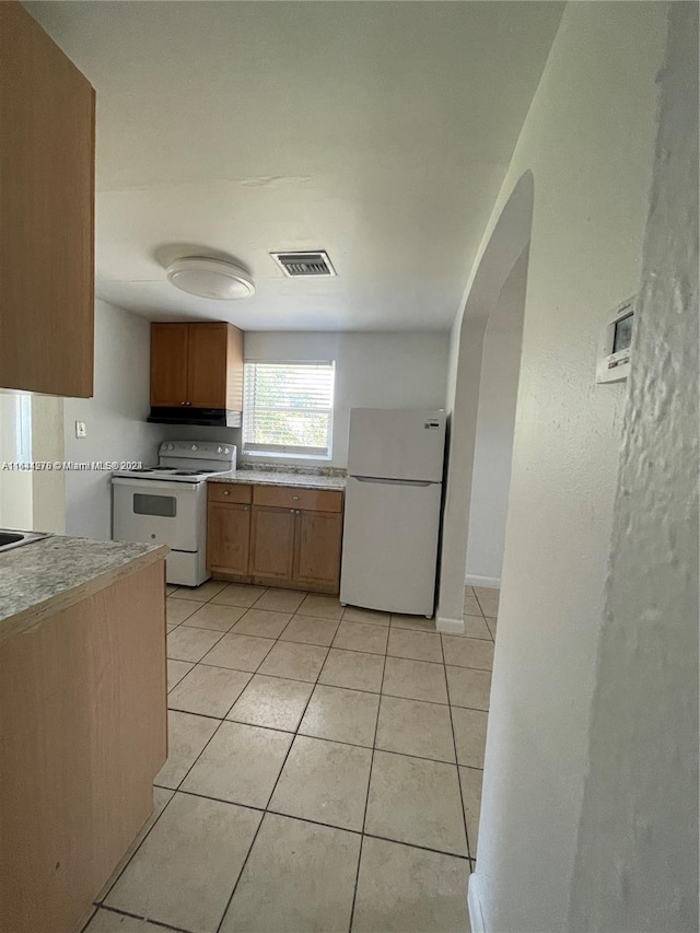 kitchen featuring sink, white appliances, light tile patterned floors, and ventilation hood