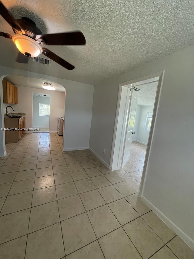 spare room featuring ceiling fan, sink, and light tile patterned floors