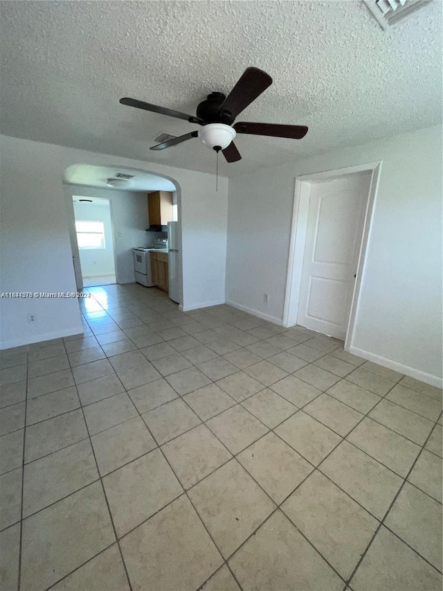 unfurnished living room with ceiling fan, light tile patterned floors, and a textured ceiling