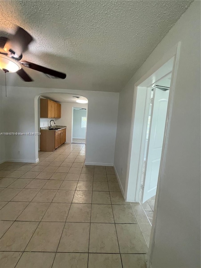 interior space featuring ceiling fan, a textured ceiling, and sink