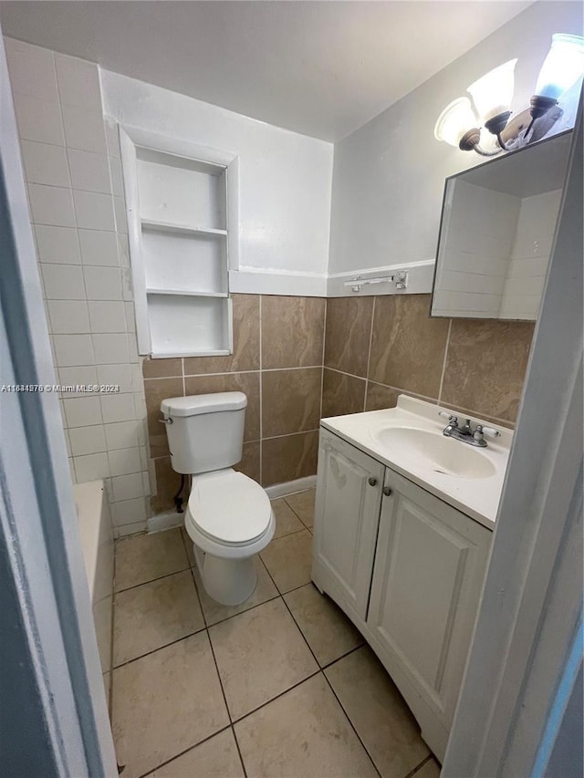 bathroom featuring vanity, tasteful backsplash, tile patterned floors, tile walls, and toilet