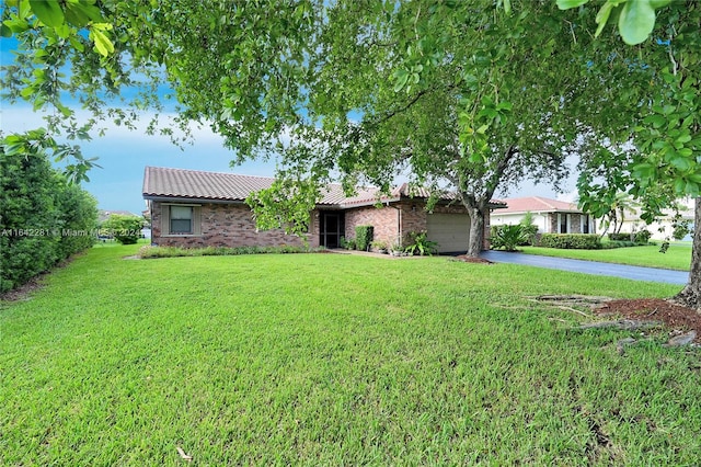 ranch-style home with a garage and a front lawn