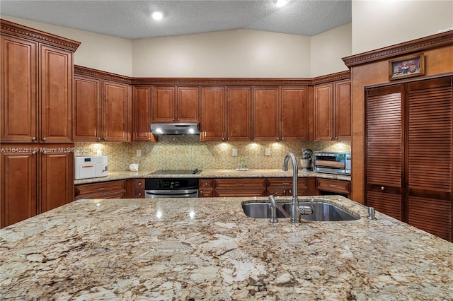 kitchen featuring a textured ceiling, sink, vaulted ceiling, and stainless steel oven