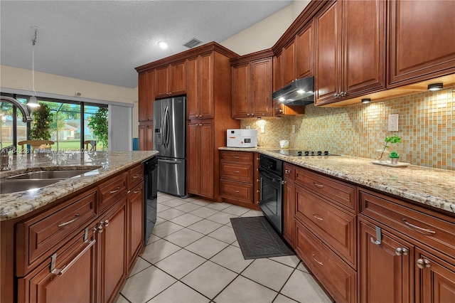 kitchen with hanging light fixtures, light stone counters, sink, and black appliances