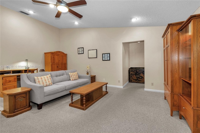 living room with a textured ceiling, light colored carpet, ceiling fan, and lofted ceiling