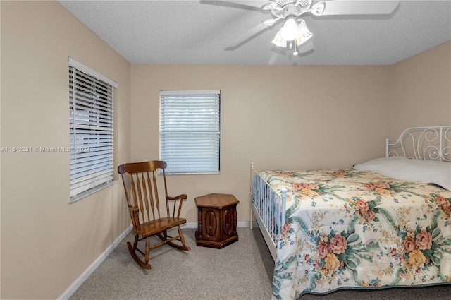 bedroom featuring ceiling fan, light carpet, and a textured ceiling