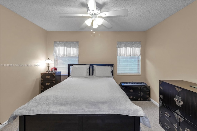 bedroom featuring multiple windows, ceiling fan, light colored carpet, and a textured ceiling