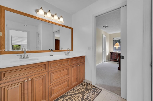 bathroom featuring tile patterned floors, vanity, and a textured ceiling