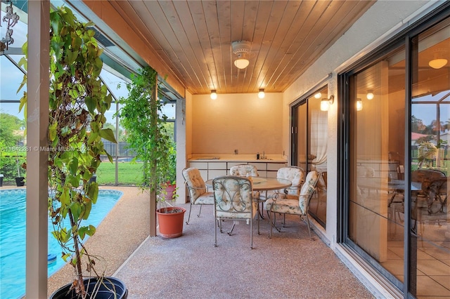 sunroom with wooden ceiling and sink