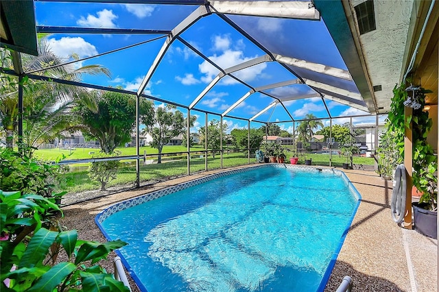 view of pool featuring a lawn and glass enclosure