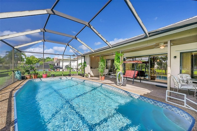 view of swimming pool with a lanai, ceiling fan, and a patio area