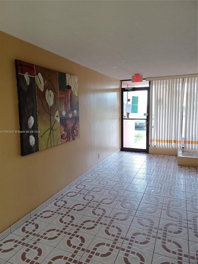 tiled empty room with floor to ceiling windows