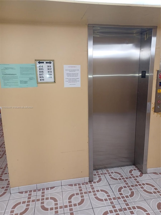 hall featuring elevator and light tile patterned floors