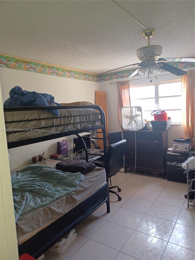 tiled bedroom featuring a textured ceiling and ceiling fan