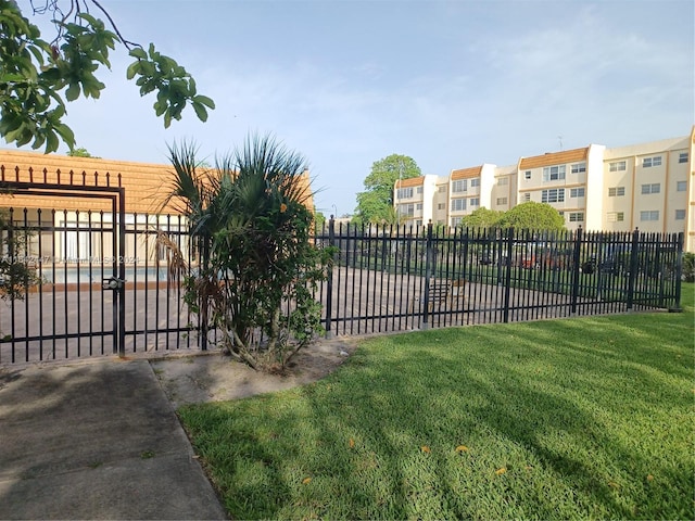 view of gate with a lawn