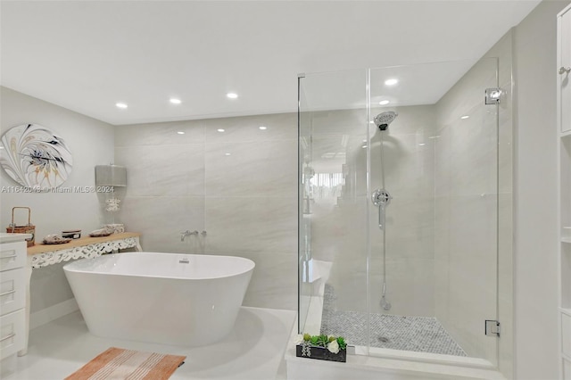 bathroom featuring tile patterned floors, tile walls, separate shower and tub, and vanity