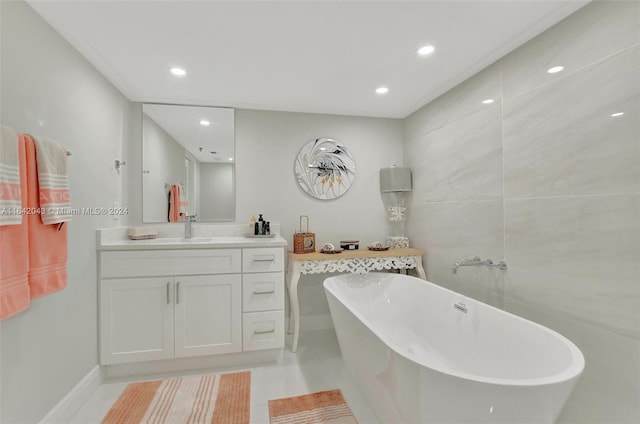 bathroom with a washtub, tile patterned flooring, and vanity