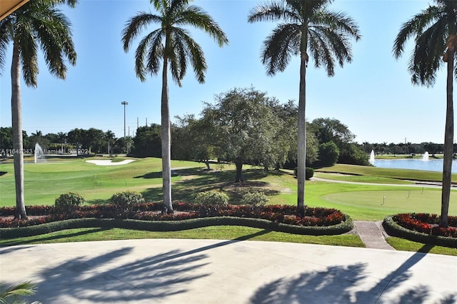 surrounding community featuring a lawn and a water view