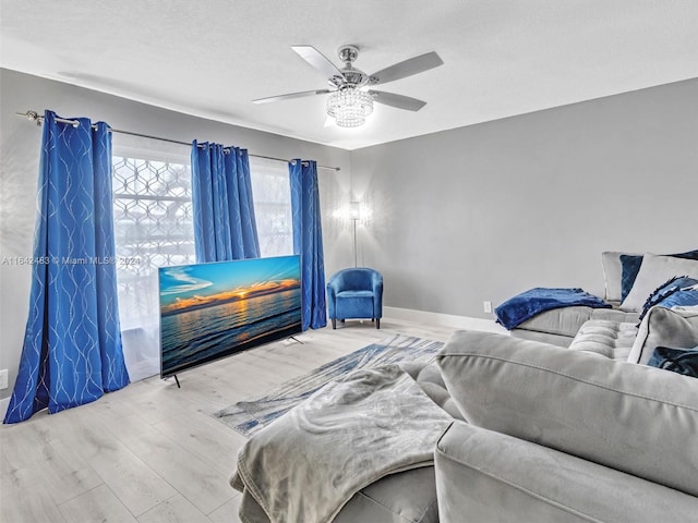 living room with ceiling fan, a textured ceiling, and hardwood / wood-style flooring