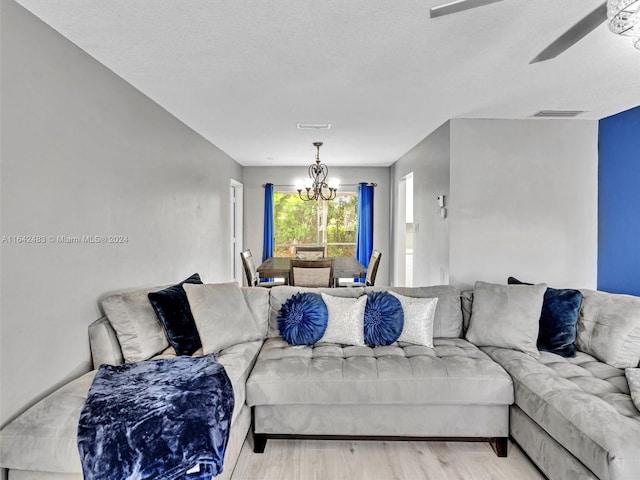 living room with light hardwood / wood-style flooring and ceiling fan with notable chandelier