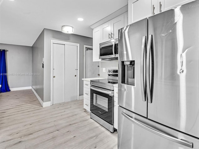 kitchen with white cabinets, light wood-type flooring, and appliances with stainless steel finishes