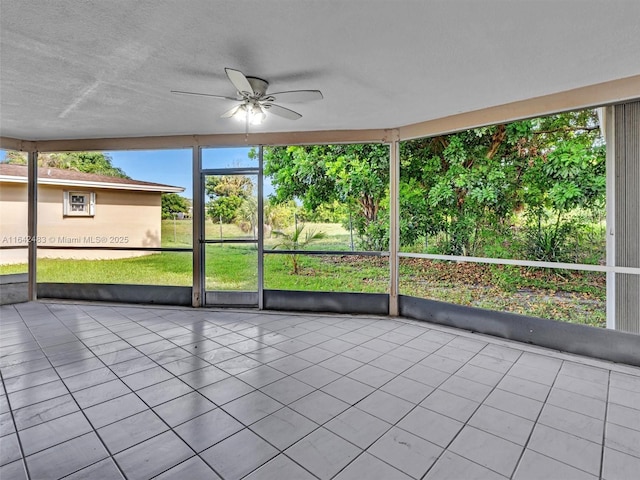 unfurnished sunroom with ceiling fan