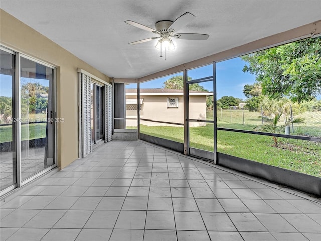 unfurnished sunroom featuring a healthy amount of sunlight and ceiling fan