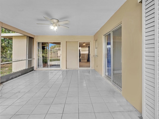 unfurnished sunroom featuring ceiling fan