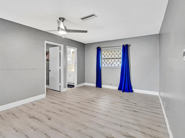 unfurnished bedroom with ceiling fan, light wood-type flooring, and ensuite bath