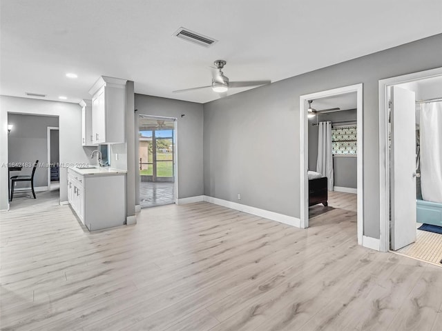 interior space with sink, ceiling fan, and light hardwood / wood-style floors