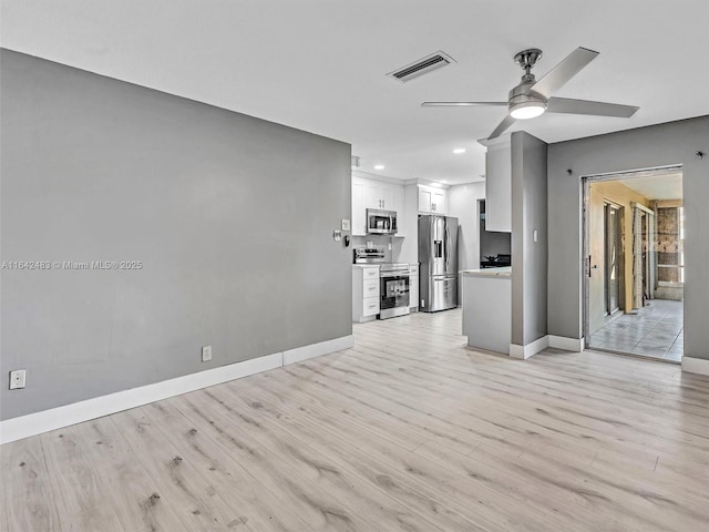 unfurnished living room featuring ceiling fan and light hardwood / wood-style flooring