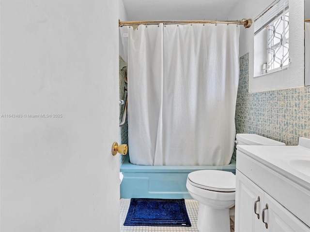 full bathroom with shower / bathtub combination with curtain, tile patterned flooring, tile walls, vanity, and toilet