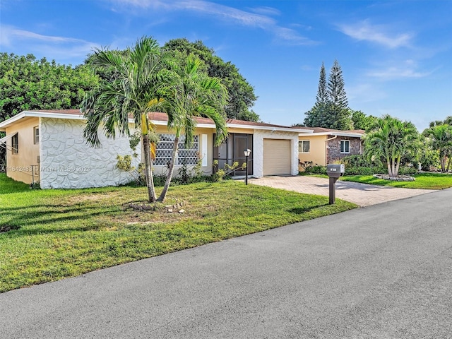 ranch-style home featuring a front lawn and a garage