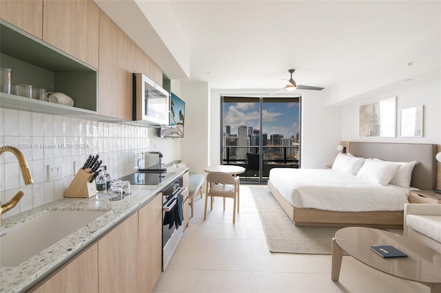 tiled bedroom featuring ceiling fan and sink