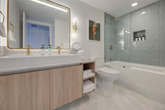 full bathroom with tile patterned flooring, double sink vanity, tiled shower / bath combo, and toilet