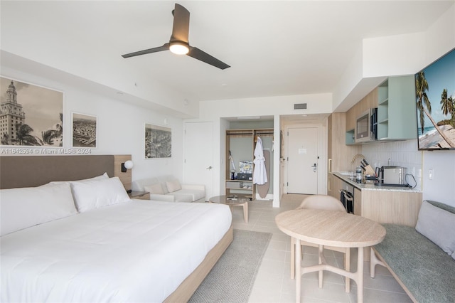 bedroom featuring sink, a closet, ceiling fan, and light tile patterned floors