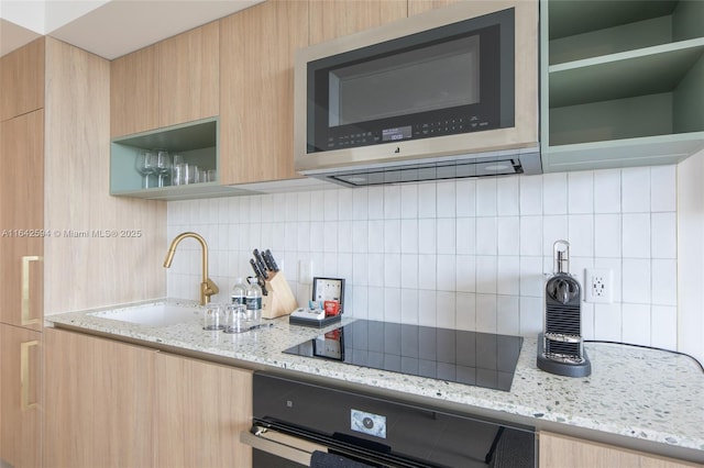 kitchen with open shelves, stainless steel microwave, black electric stovetop, a sink, and modern cabinets