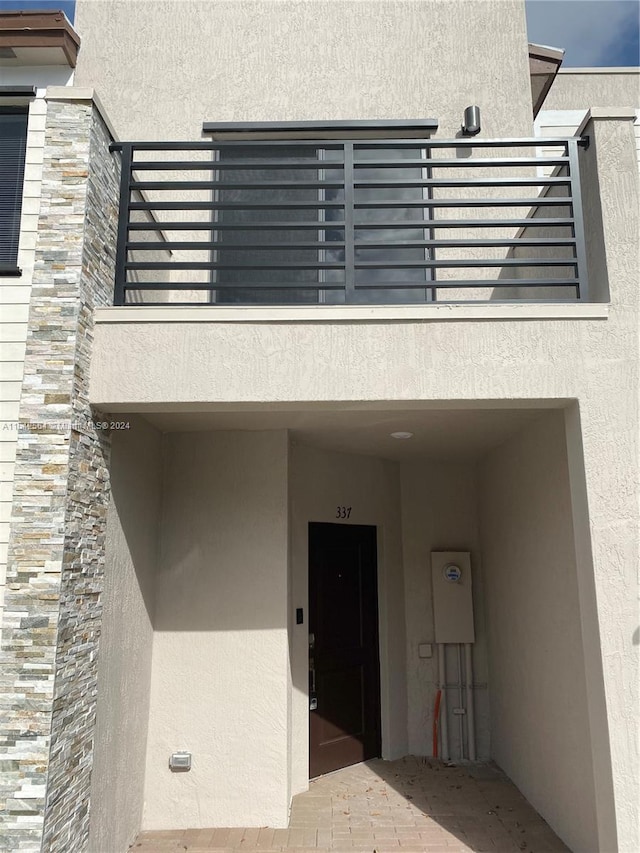 doorway to property with a balcony and elevator