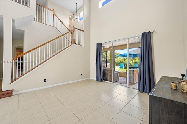 unfurnished living room with a high ceiling and light tile patterned floors