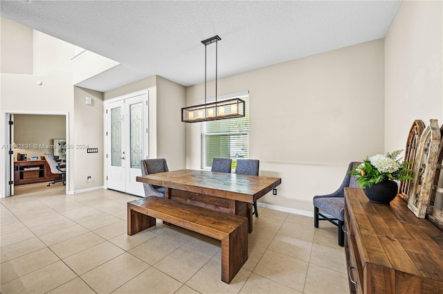 tiled dining area featuring a textured ceiling