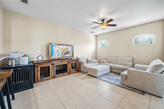 living room with light tile patterned floors, a textured ceiling, and ceiling fan