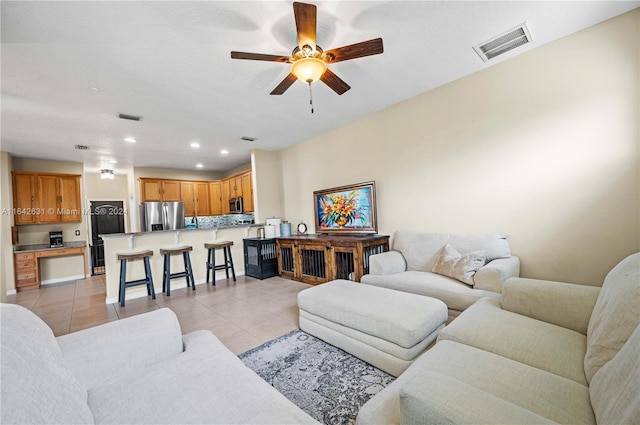 living room with ceiling fan and light tile patterned floors