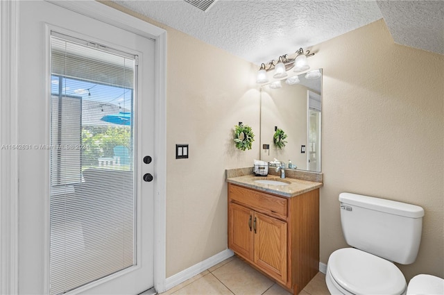 bathroom with tile patterned floors, vanity, toilet, and a textured ceiling