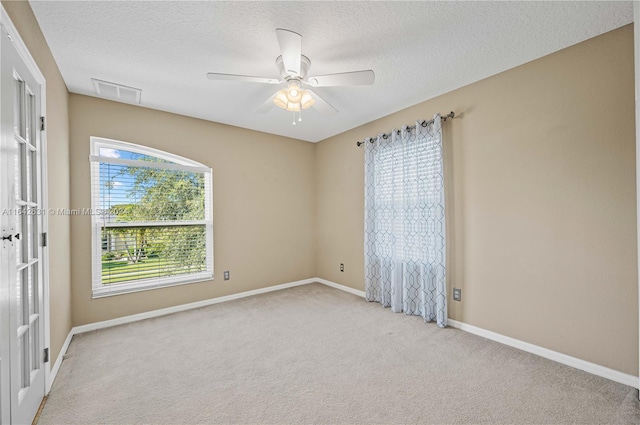 carpeted spare room with ceiling fan and a textured ceiling