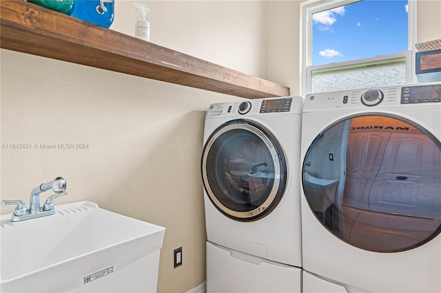 clothes washing area featuring separate washer and dryer and sink