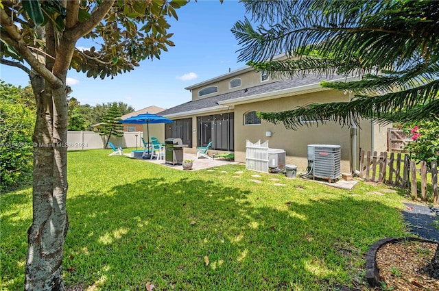 rear view of house featuring a yard, cooling unit, and a patio area