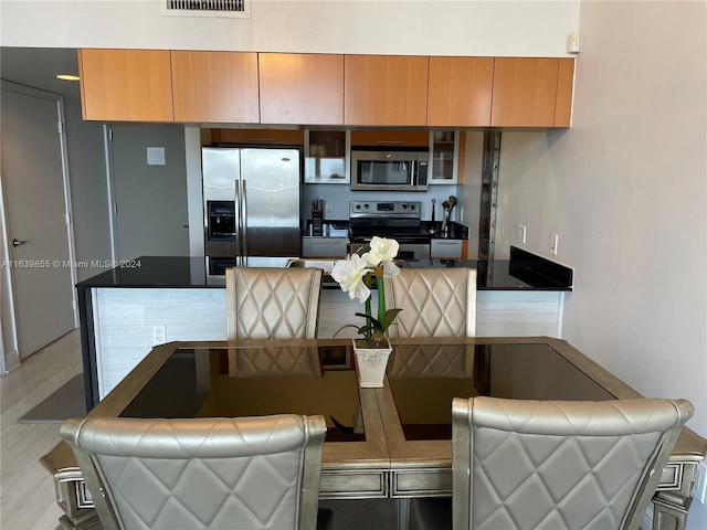 kitchen featuring light wood-type flooring and appliances with stainless steel finishes