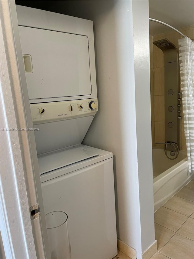 washroom featuring stacked washer and dryer and light tile patterned floors