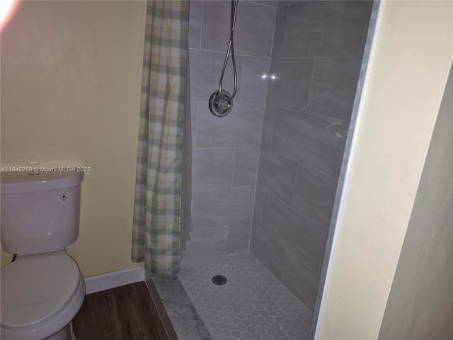 bathroom featuring toilet, hardwood / wood-style floors, and a shower with shower curtain